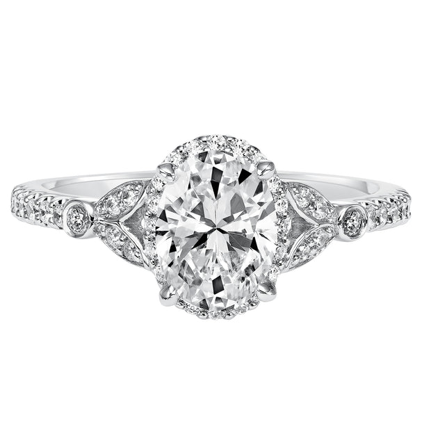 This romantic and beautiful engagement ring features an oval cut diamond accentuated by a prong set diamond halo and petal-inspired band design